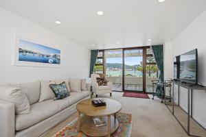 uma sala de estar com um sofá e uma mesa em Bay Suites - 328 Oriental Parade Wellington em Wellington