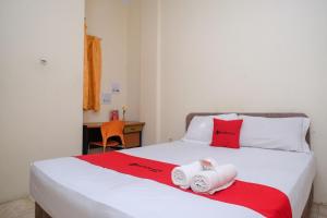 a bedroom with a bed with towels on it at RedDoorz near Jalan Wolter Monginsidi Manado in Manado