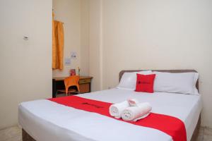 a bedroom with a bed with two towels on it at RedDoorz near Jalan Wolter Monginsidi Manado in Manado