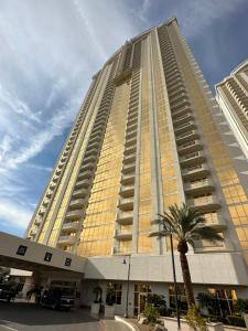 a tall building with a palm tree in front of it at MGM SIGNATURE - Balcony Suite Strip View - FREE valet parking in Las Vegas