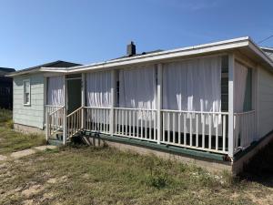a house with a porch with curtains on it at Queen Anne's Revenge at the Beach cottage in Kitty Hawk