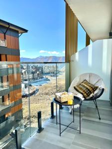 a room with a chair and a table with a view at Gudauri Atrium in Gudauri
