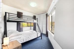 1 dormitorio con litera y ventana en Tindarra Apartments, en Alexandra Headland