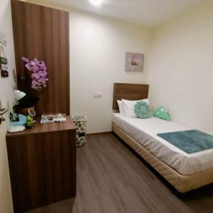 um quarto com uma cama grande e uma mesa de madeira em SCC Velodrome KL em Kuala Lumpur