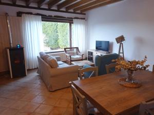 a living room with a table and a couch at Casa con encanto en La Hayuela, situada a 5 min de Comillas in Udias