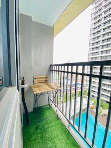 Cozy 1Br with Netflix & Balcony Pool View Condo في مانيلا: شرفة مع طاولة خشبية ومسبح