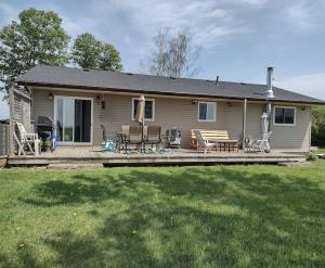 a house with a deck with chairs and a table at Modern Rustic Home with Wood Stove & Pool Table in Kemble
