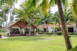 una casa con palme di fronte di El Matcha Lanta Resort a Phra Ae beach