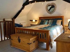 a bedroom with a wooden bed with a dresser and a mirror at Easterly Cottage in Bude