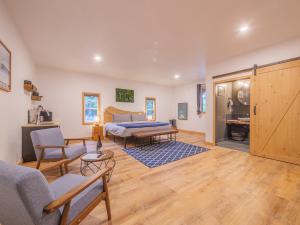 uma sala de estar com uma cama e uma mesa em Winter's Hideaway Suite em Ucluelet