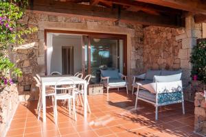 a patio with a table and chairs on a stone wall at Villa Valentina 250m From The Beach - Happy Rentals in Puntaldia