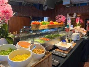 a buffet with bowls of food on a counter at Double - Six, Luxury Hotel - Seminyak in Seminyak