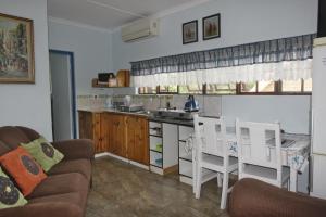 a kitchen with a couch and a table and chairs at Xanadu Guest House in Sea Park +28 photos