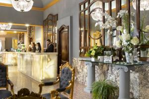 a lobby with a bar with a man standing at a counter at Golden Tulip Rome Piram in Rome