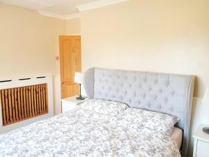 a bedroom with a large bed with a white headboard at Specious 3bed property with parking & large garden in Aveley