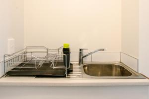 a dish drying rack next to a kitchen sink at Wanaka Riverside 1 Bedroom Apartment in Wanaka