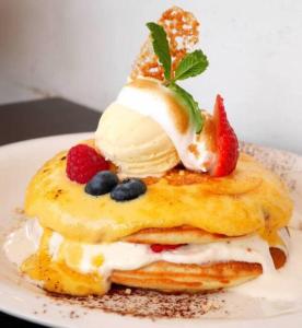 a stack of pancakes with fruit on a plate at Daikanyama 42 VALUE ADD Apartments in Tokyo