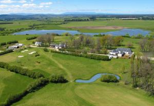 an aerial view of a golf course with a lake at Quamby Estate in Hagley