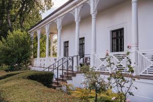 Biały dom z białymi kolumnami i schodami w obiekcie Quamby Estate w mieście Hagley