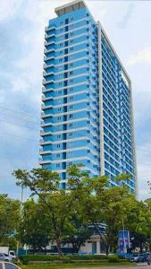 un gran edificio azul con árboles delante de él en CityView Condo with balcony-12, en Cagayan de Oro