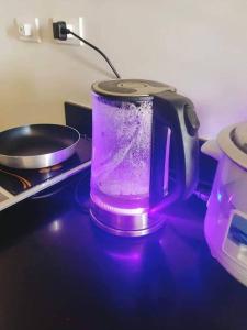 una licuadora púrpura sentada sobre una estufa en CityView Condo with balcony-12, en Cagayan de Oro