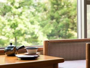 uma mesa com um bule de chá e uma chávena sobre ele em Shin Kabakawa Kanko Hotel em Takamatsu