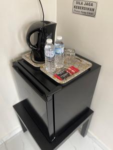 - une table noire avec 2 bouteilles d'eau dans l'établissement Aufa Roomstay, à Pendang