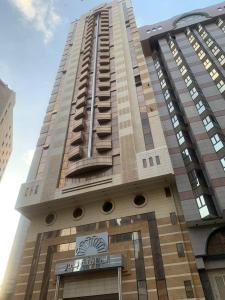 a tall building with a sign in front of it at Al Massa Bader Hotel in Makkah