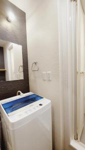 y baño con lavadora y espejo. en Poly Hostel Osaka, en Osaka