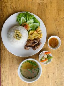 HeangKanha GuestHouse في Phumĭ Chŏng Kaôh: طبق من الطعام مع الرز والخضار على الطاولة