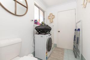 a bathroom with a washing machine and a mirror at The Reef in Boomerang Beach