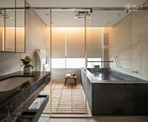 bagno con ampia vasca e lavandino di 蘊泉庄 Yun Estate Hotel a Tamsui