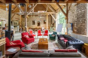 a living room with couches and chairs and a table at La Ferme des Isles in Authouillet