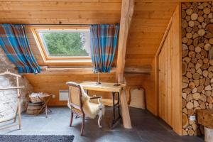 a wooden cabin with a desk and a window at La Ferme des Isles in Authouillet