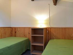 Zimmer mit 2 grünen Betten und einer Lampe in der Unterkunft Maison Fleury-Saint-Pierre-la-Mer, 3 pièces, 4 personnes - FR-1-229D-84 in Fleury