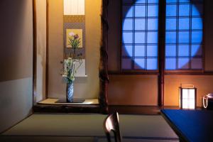 un jarrón sentado en una mesa junto a una ventana en Ohanabo en Kyoto