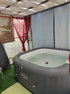 una grande vasca idromassaggio in una tenda con una camera con finestra di Charmant studio dans le sud, idéal pour un couple a Trois Mares-les Hauts
