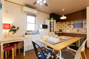 uma cozinha com mesa e cadeiras e uma cozinha com geladeira em Seaside House Enoshima 江ノ島, Free Parking 漫居湘南海岸, 尋訪灌籃高手 em Koshigoe