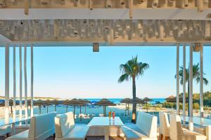 a view of the beach from a restaurant with tables and chairs at So Nice Club Resort in Ayia Napa