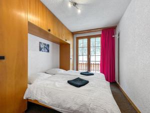 a bedroom with two beds and a window at Les Mayens de l'Ours - At the foot of Piste de l'Ours' slope! in Agettes