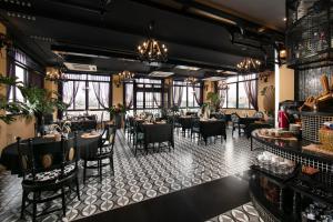 a dining room with tables and chairs and windows at JM Marvel Hotel & Spa in Hanoi