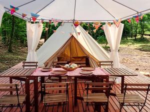 een tent met een tafel en stoelen ervoor bij リバーサイドグランピングNuts in Higashiomi