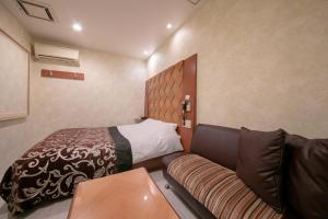 a small room with a bed and a couch at Hotel Vanilla (Adult Only) in Ueda