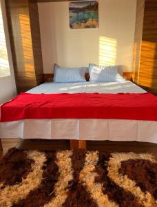 een slaapkamer met een groot bed en een rode deken bij Corner Stone in Sūlagiri