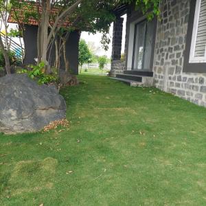 een tuin naast een huis met een boom bij Corner Stone in Sūlagiri