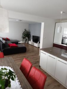 a living room with a table and red chairs at Apartma Tia 2 in Zreče