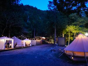 - un groupe de tentes dans un parking la nuit dans l'établissement リバーサイドグランピングNuts, à Higashiomi
