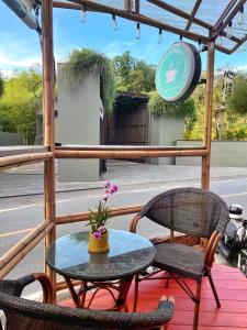 a patio with a table and two chairs and a clock at Aromdee at Naithon Beach in Nai Thon Beach +39 photos