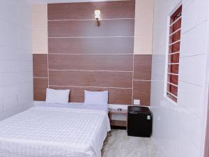 Dormitorio pequeño con cama y pared en Khách sạn Ngọc Bích 2 en Thôn Tân Hội