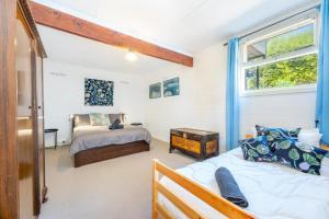 een slaapkamer met 2 bedden en een raam bij Syds Place A 70s retro beach house Free WIFI in Goolwa South